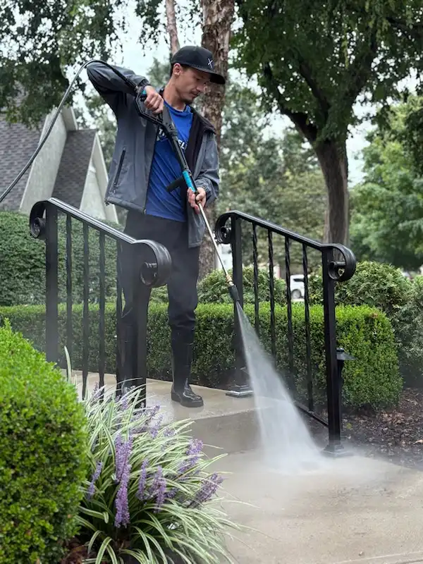 Technician pressure washing front steps of a Kansas City home